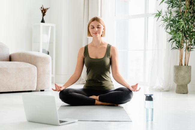 Young,Caucasian,Fit,Female,Sitting,In,Lotus,Position,During,Online